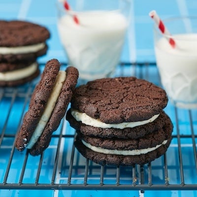 Oreo Cookies stacked on the cooling rack served with two glasses of milk.