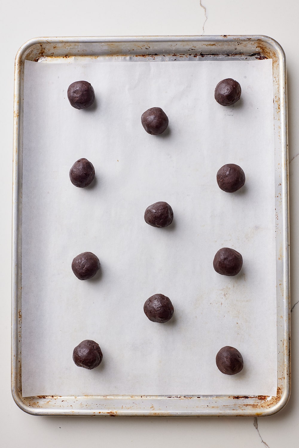 Shape dough: Scoop 1 level tablespoon of dough and place on the baking sheet approximately two inches apart. Flatten down the balls slightly with your hand.