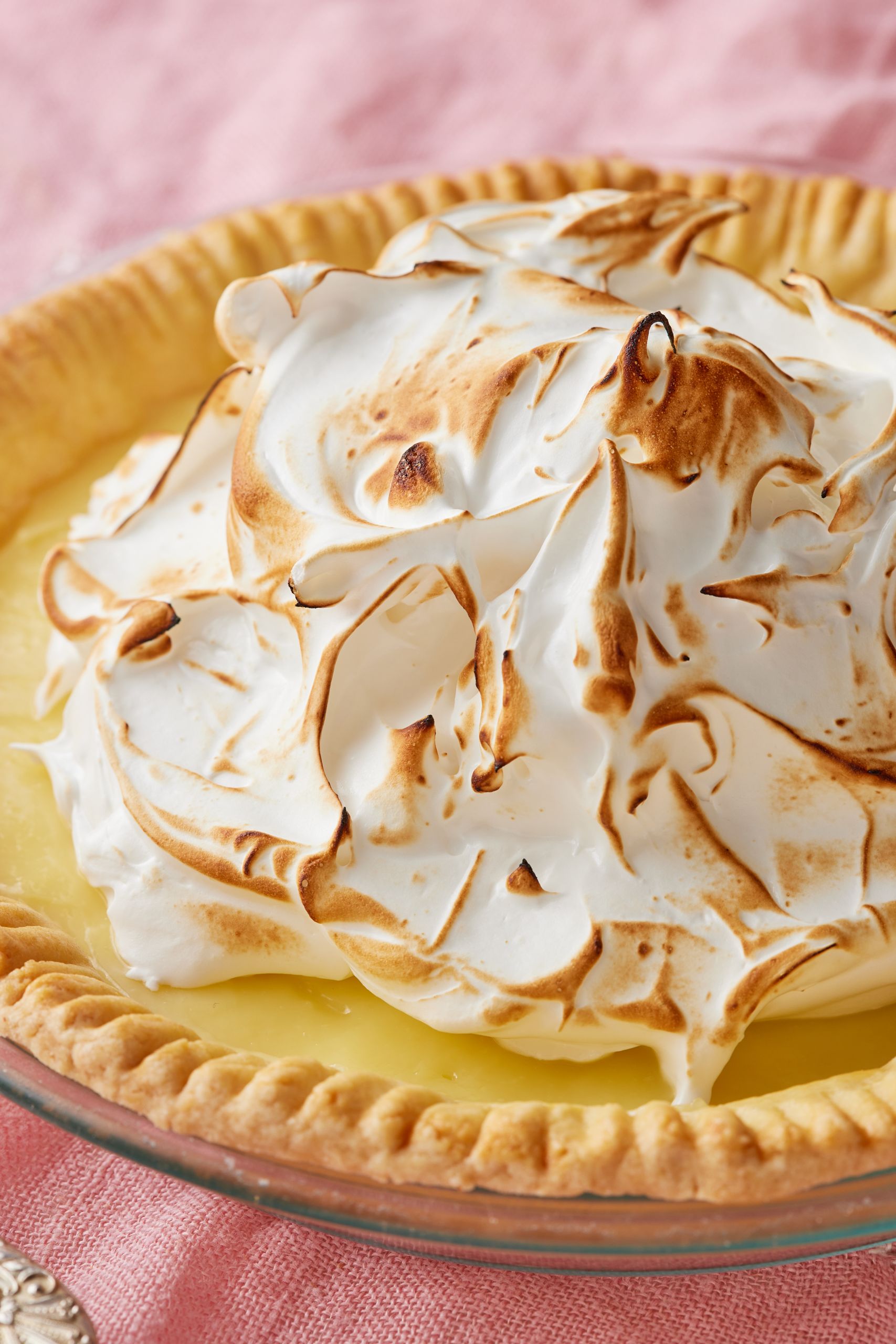 A lemon meringue pie with golden crust, smooth curd, and pillowy meringue topping that's toasted.