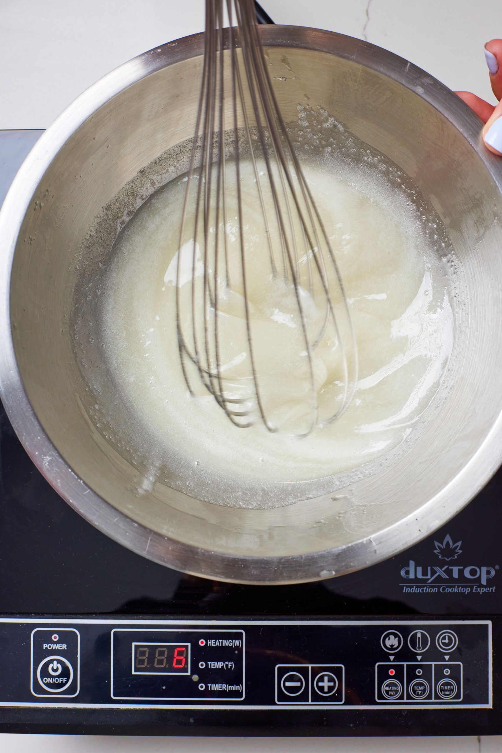 Whisk and cook the meringue mixture until sugar dissolves.