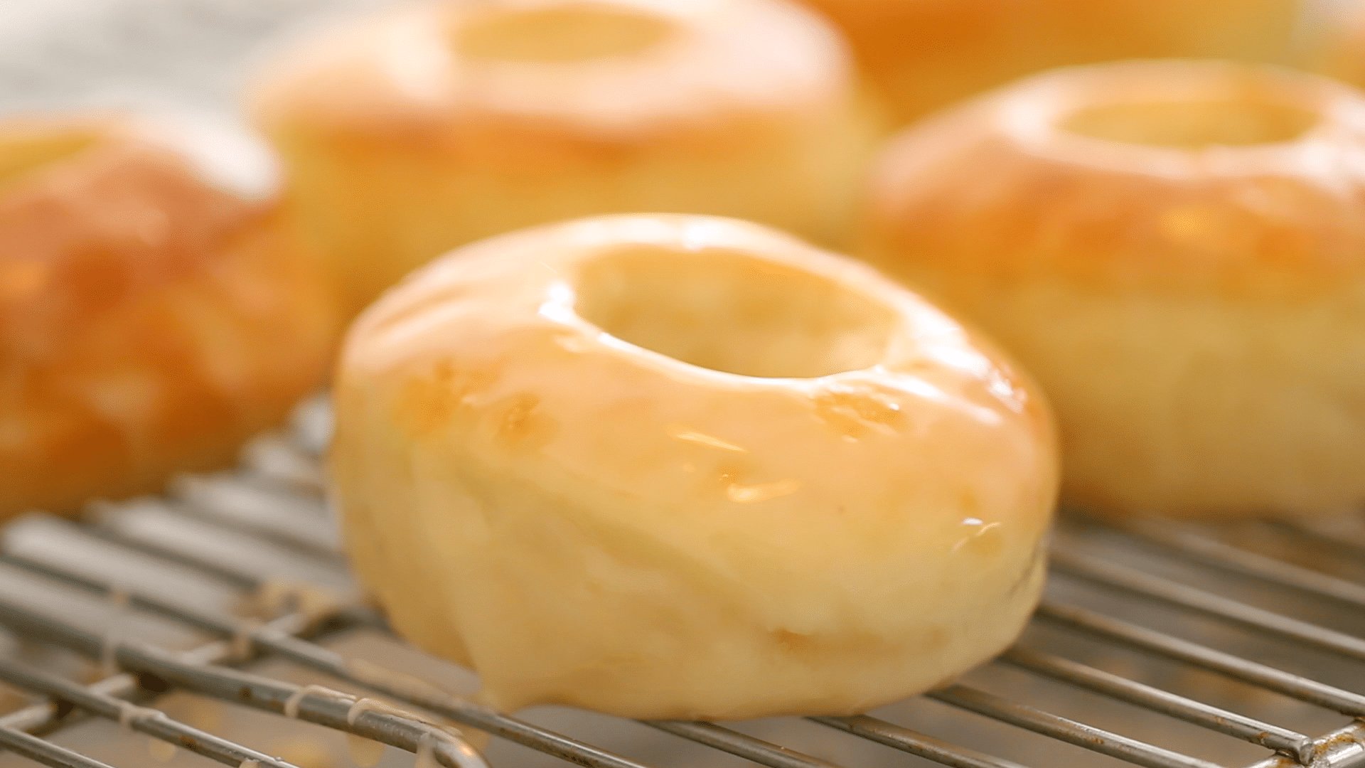 Baked glazed donuts on a cooling rack.