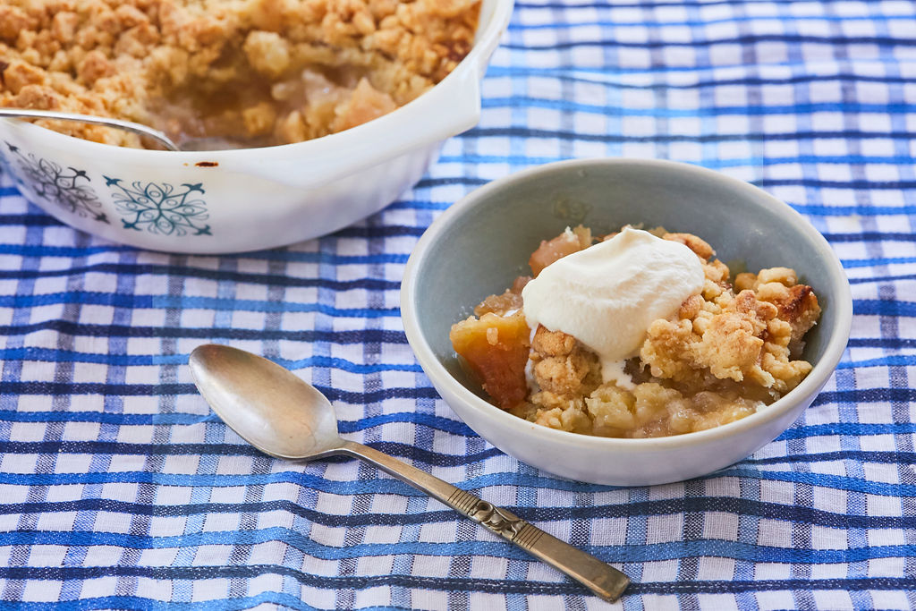 A bowl of Irish Apple Crumble with cream on top.