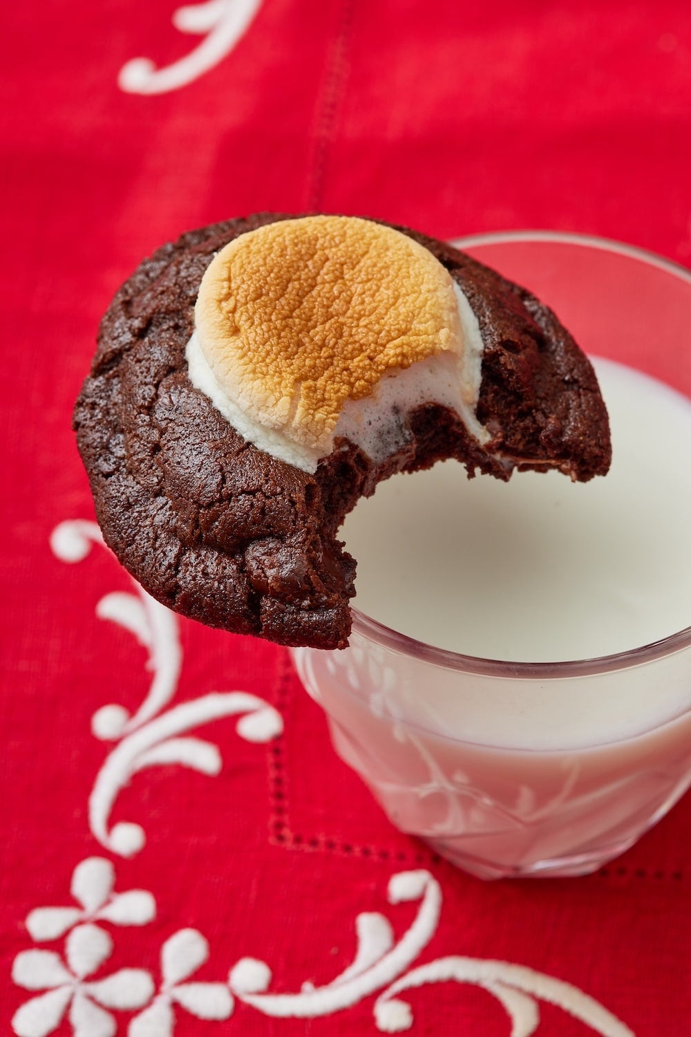 Hot Chocolate Cookies14 A Hot Chocolate Cookie on the edge of a glass, is served with milk.
