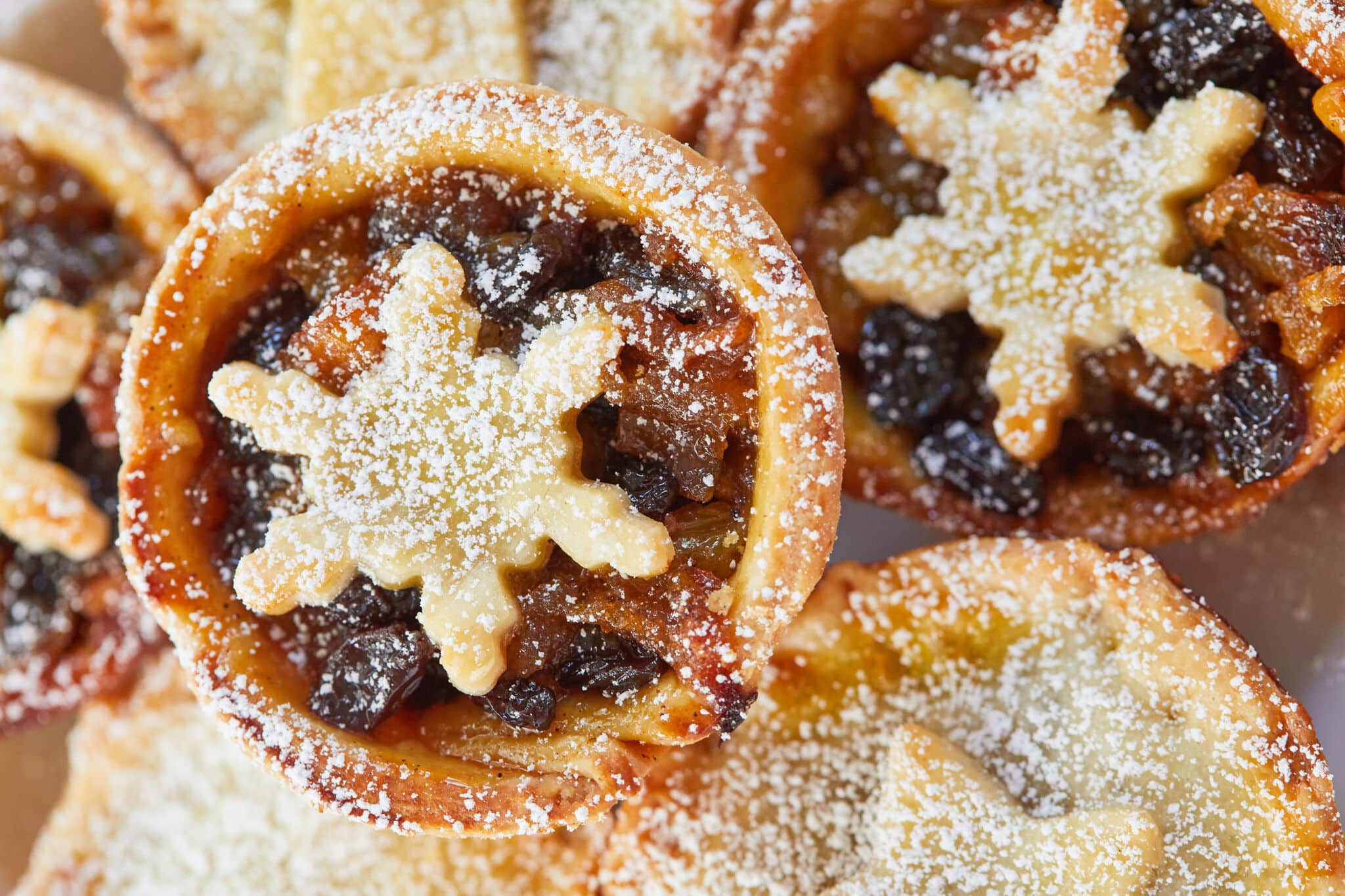 Traditional Irish Mince Pies have golden flaky pastry and slightly moist, chewy, and perfectly sticky mincemeat, dusted with powdered sugar. The top crust are shaped into snow flakes or stars.