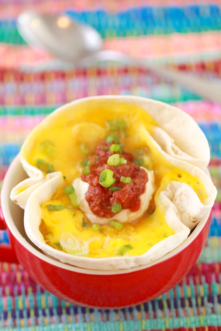 A whole breakfast in a mug: a soft tortilla with eggs, cheese, and salsa, called a mugrito, or a burrito in a mug.