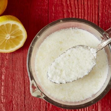 Top-down view of homemade butter milk substitute with half of fresh lemon.
