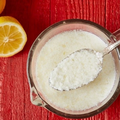 Top-down view of homemade butter milk substitute with half of fresh lemon.