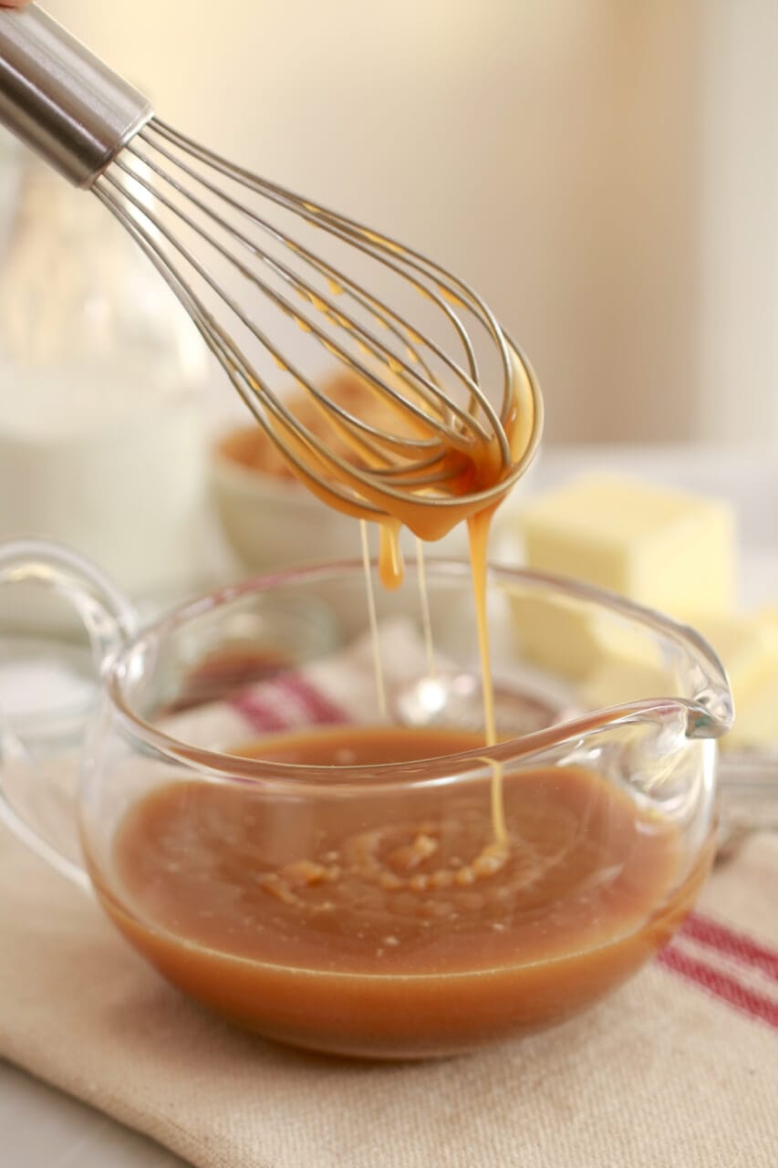 Caramel sauce dripping from a whisk
