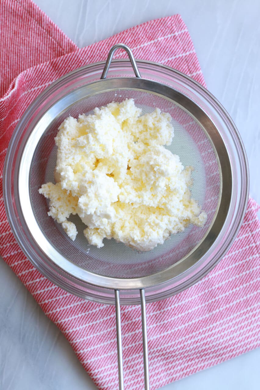 Homemade butter over a sieve.
