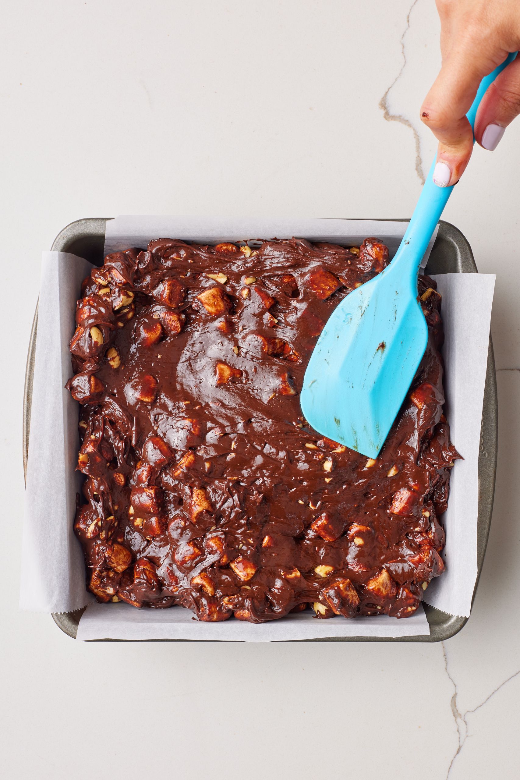 Pour the fudge batter into a parchment lined baking pan and smooth the top with a spatula. 