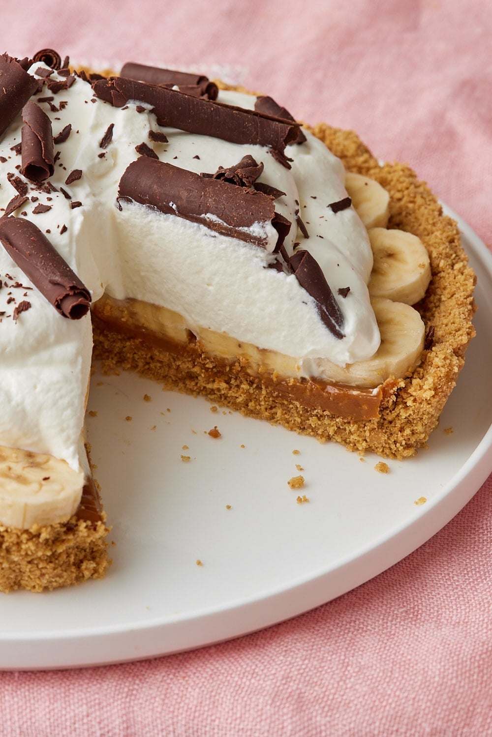 Banoffee Pie8 Slice of Banoffee Pie with bananas, dulce de leche, whipped cream, and chocolate curls in a graham cracker crust.