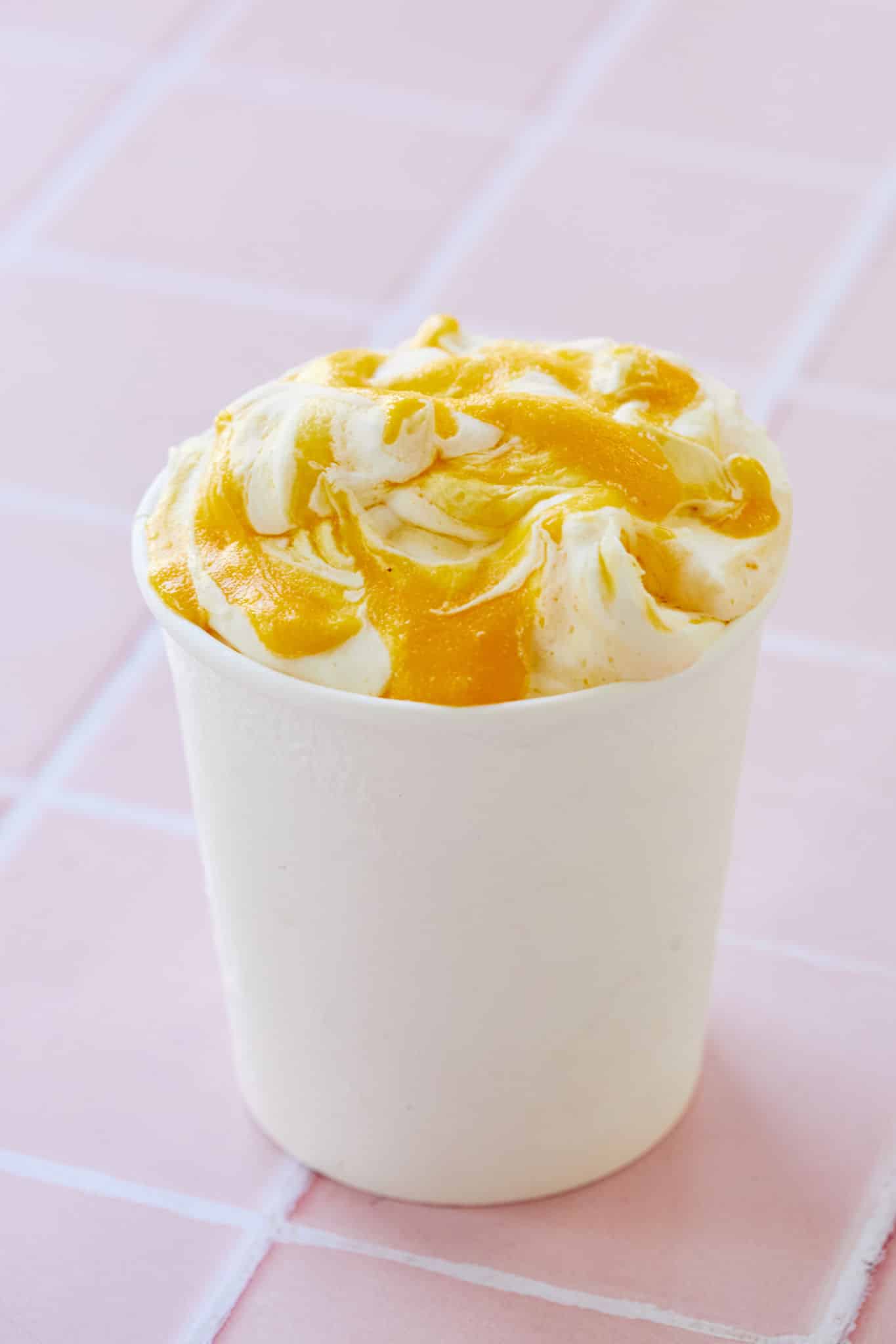 Fresh mango ice cream in a container for freezing