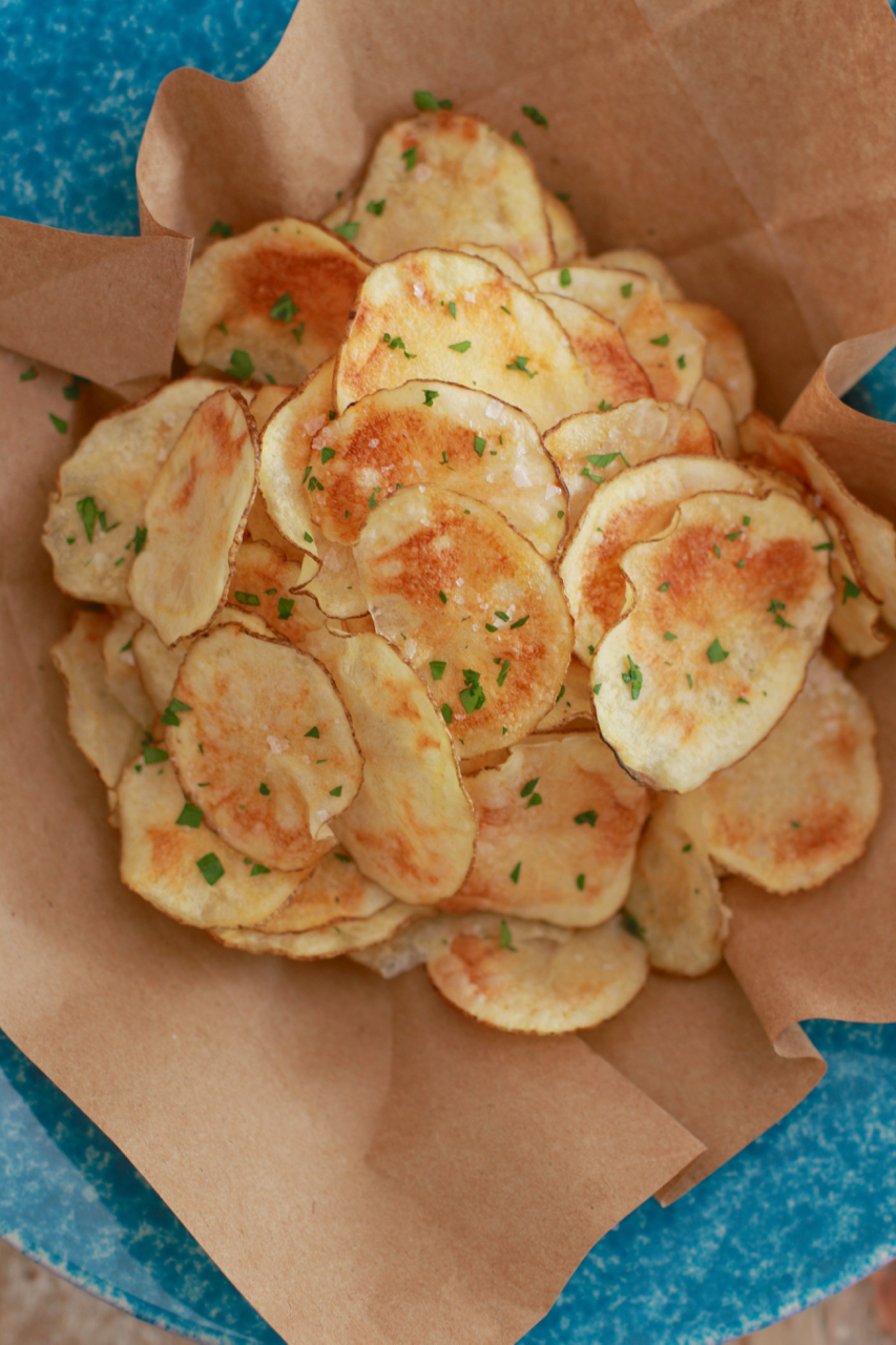 A basket of microwavable homemade potato chips, topped with salt.