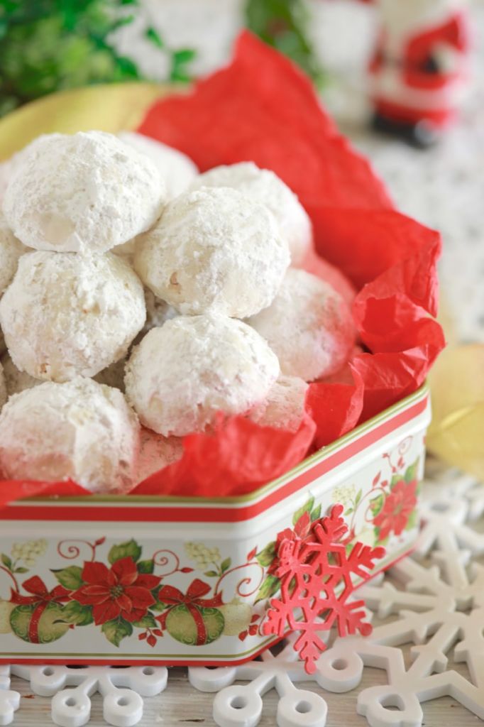 Classic Snowball Cookies, or Christmas Snowball Cookies, baked and displayed in a decorative tin, covered in powdered sugar.
