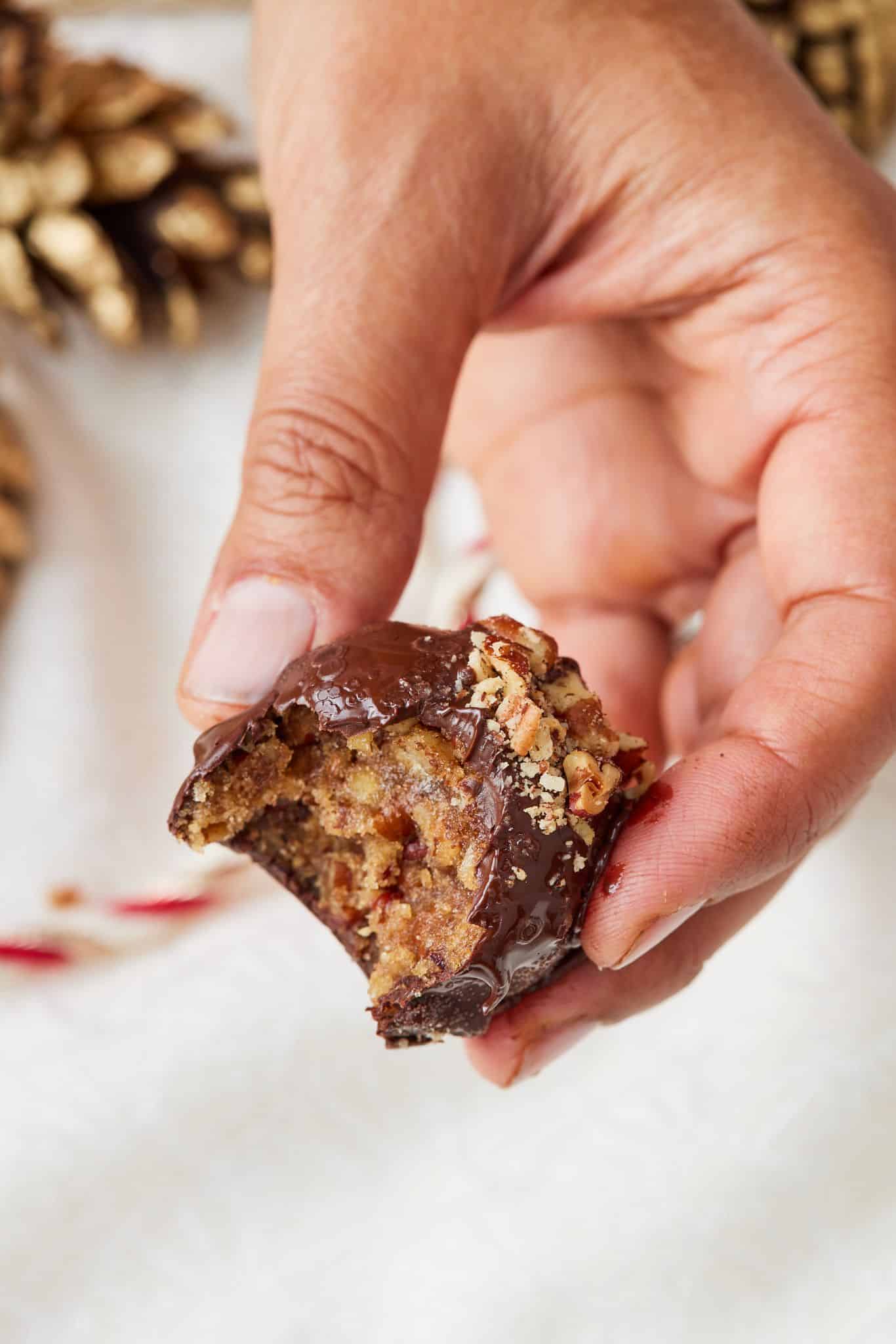 A close-up shot at a pecan pie ball with one bite taken .