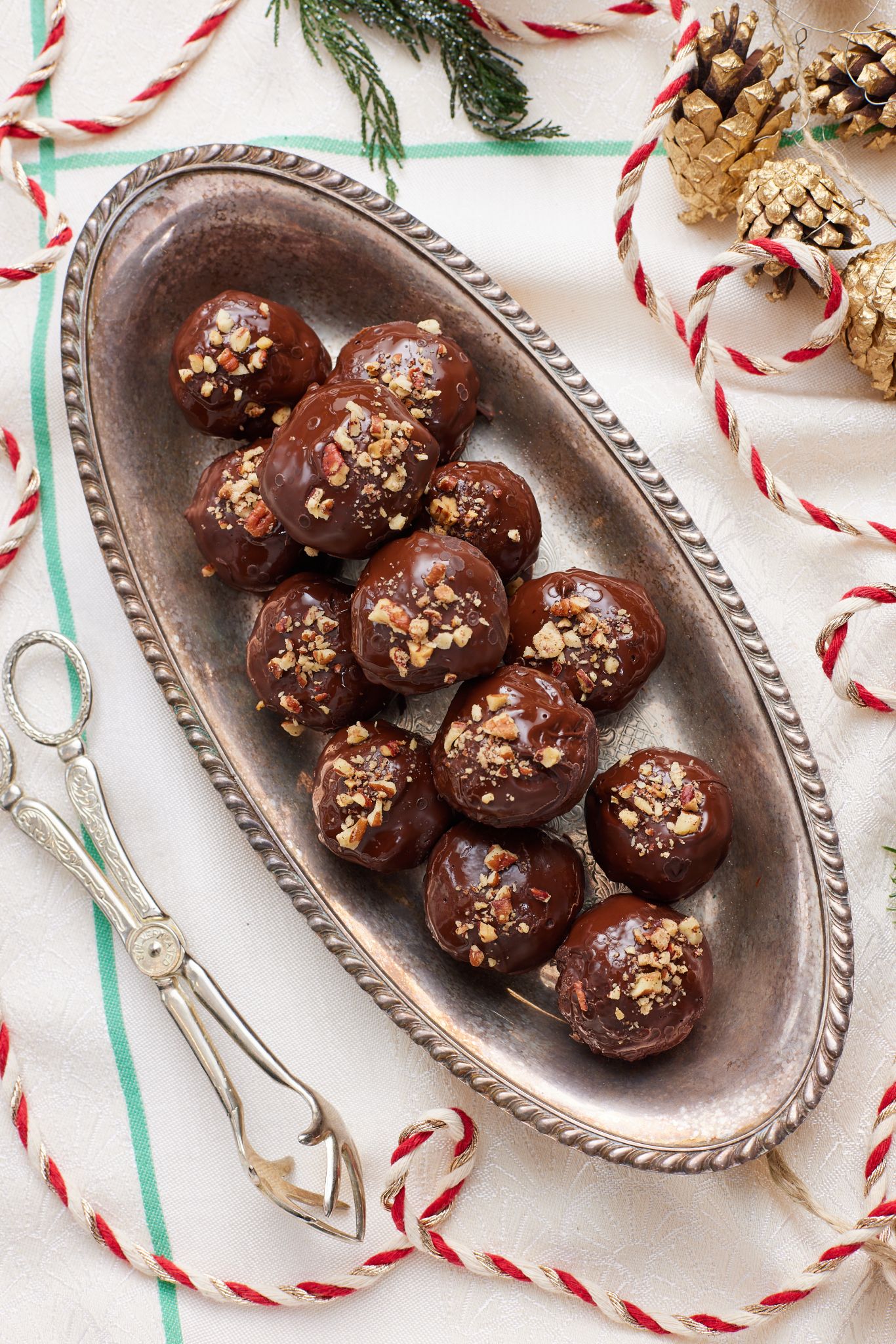 A top down view of a platter of chocolate coated pecan pie balls. 