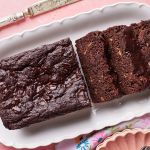 Half loaf of Healthy Chocolate Banana Bread with three slices on a platter.