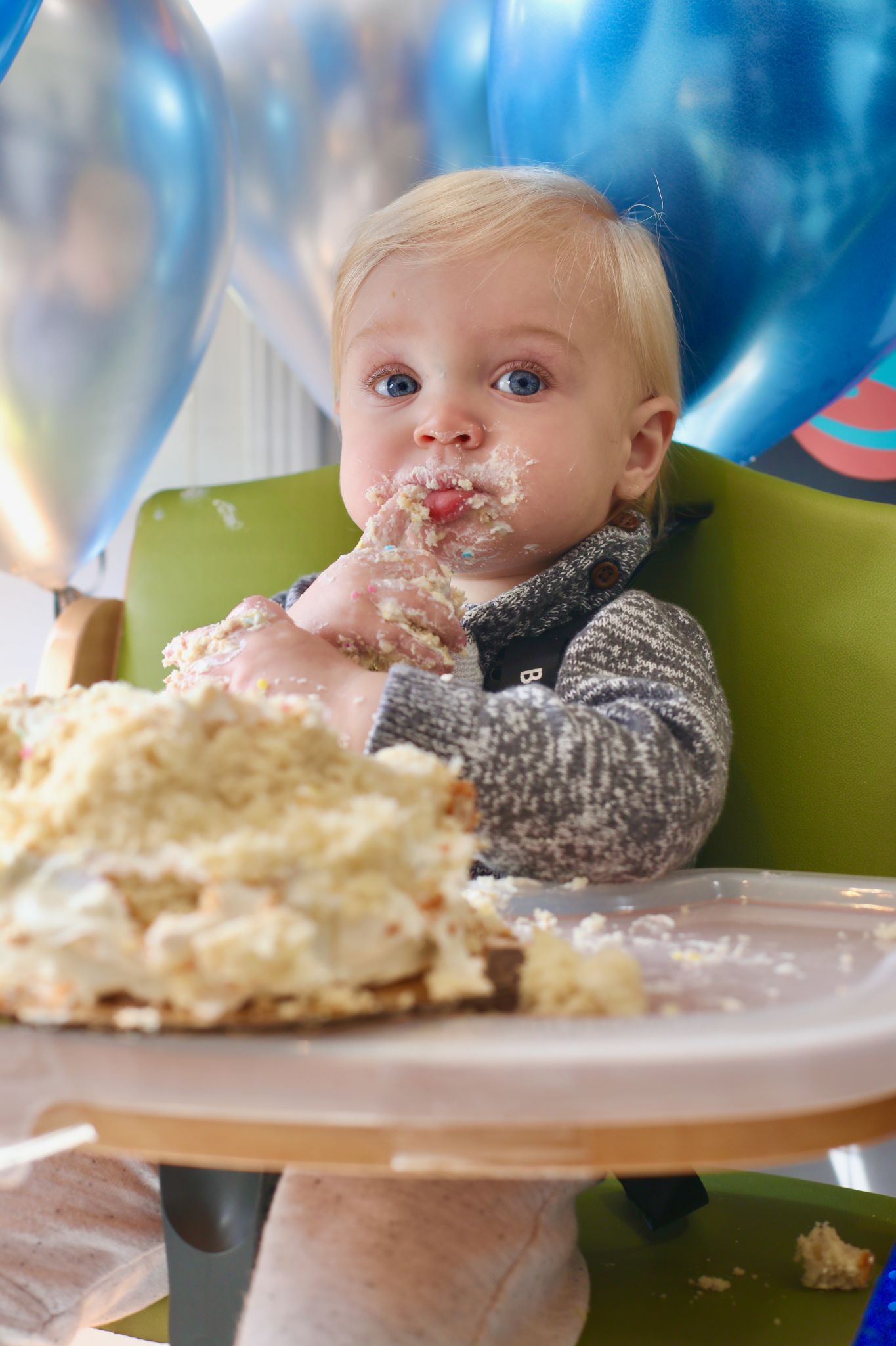 A baby with cake all over his face.