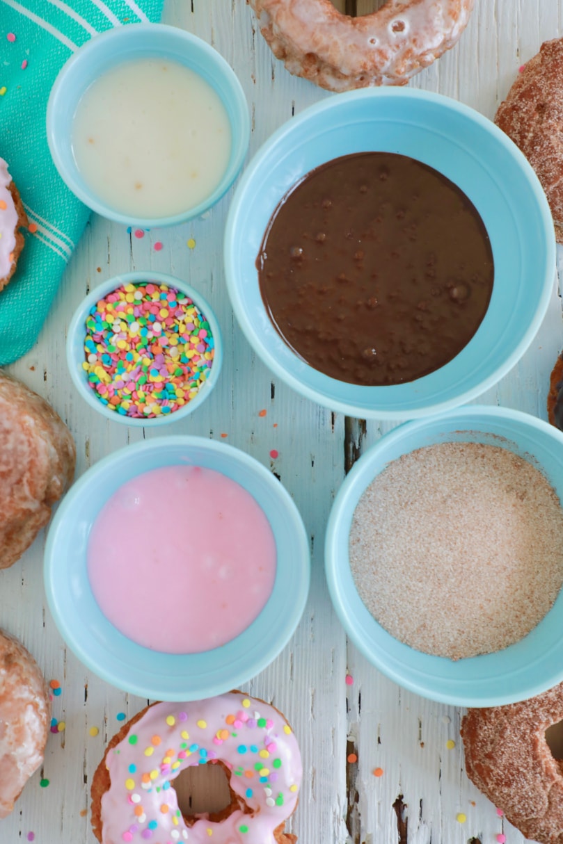 A top-down view of my donut glaze recipes — vanilla, funfetti, chocolate, maple, and cinnamon sugar.