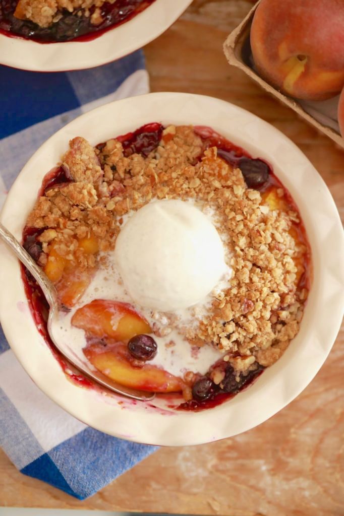Peach and Blueberry Crisp Recipe Topped with Ice Cream