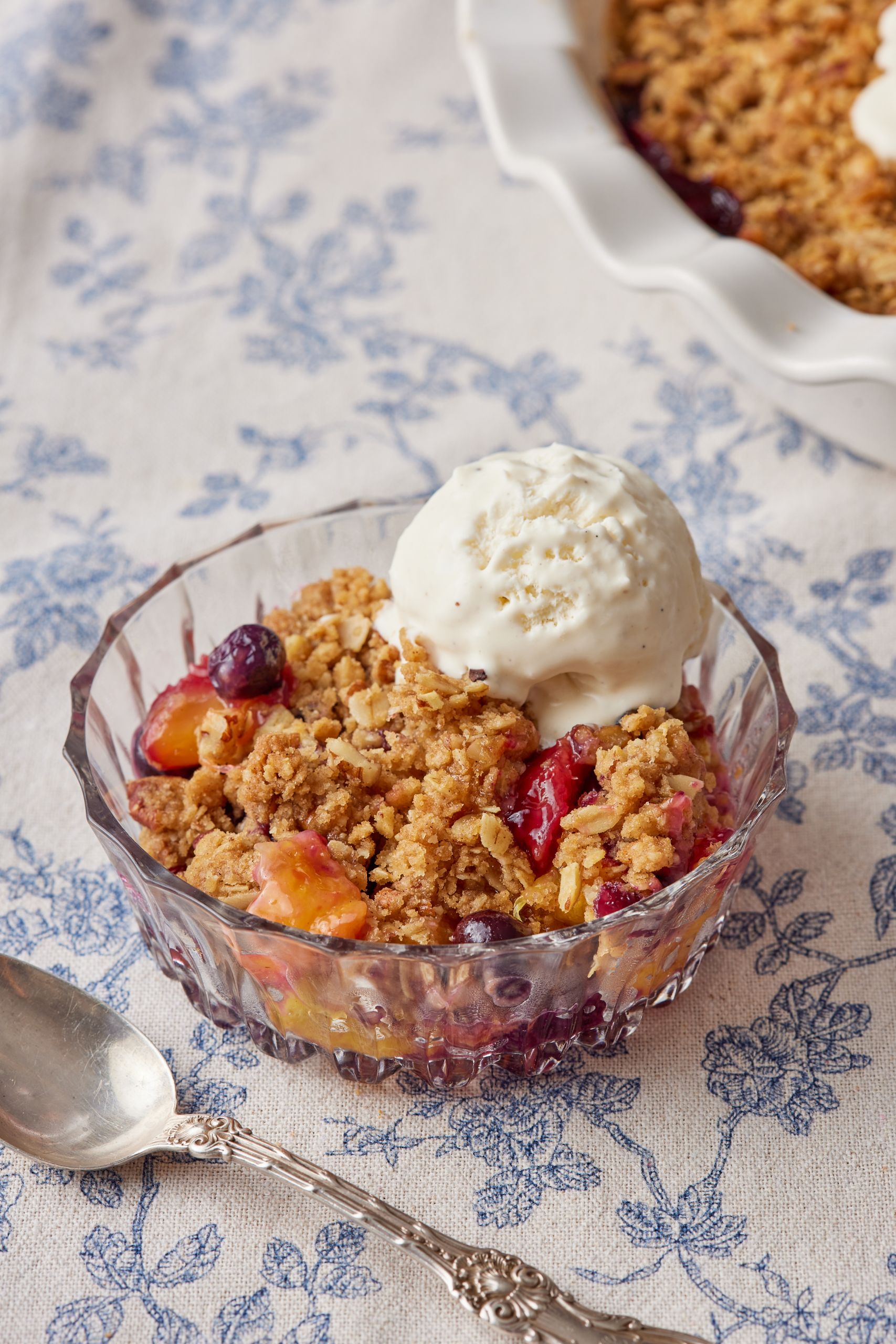 A bowl of peach blueberry crips served with ice cream