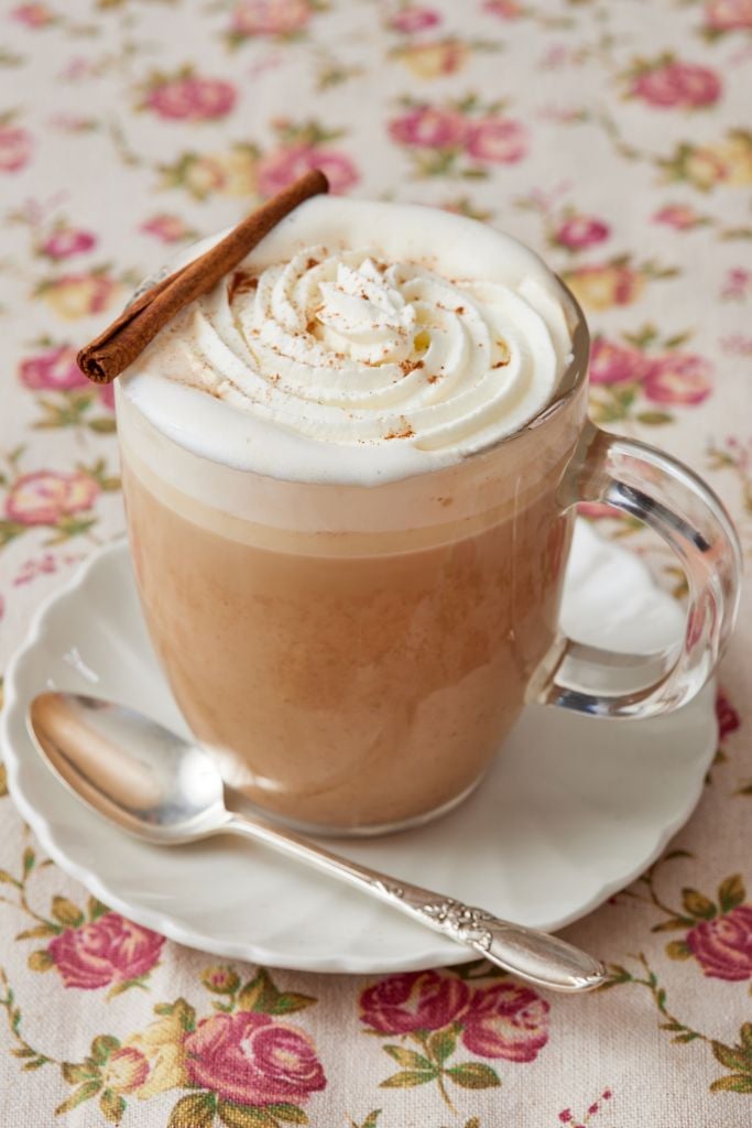 Pumpkin Spice Latte served with whipped cream and a cinnamon stick on top.