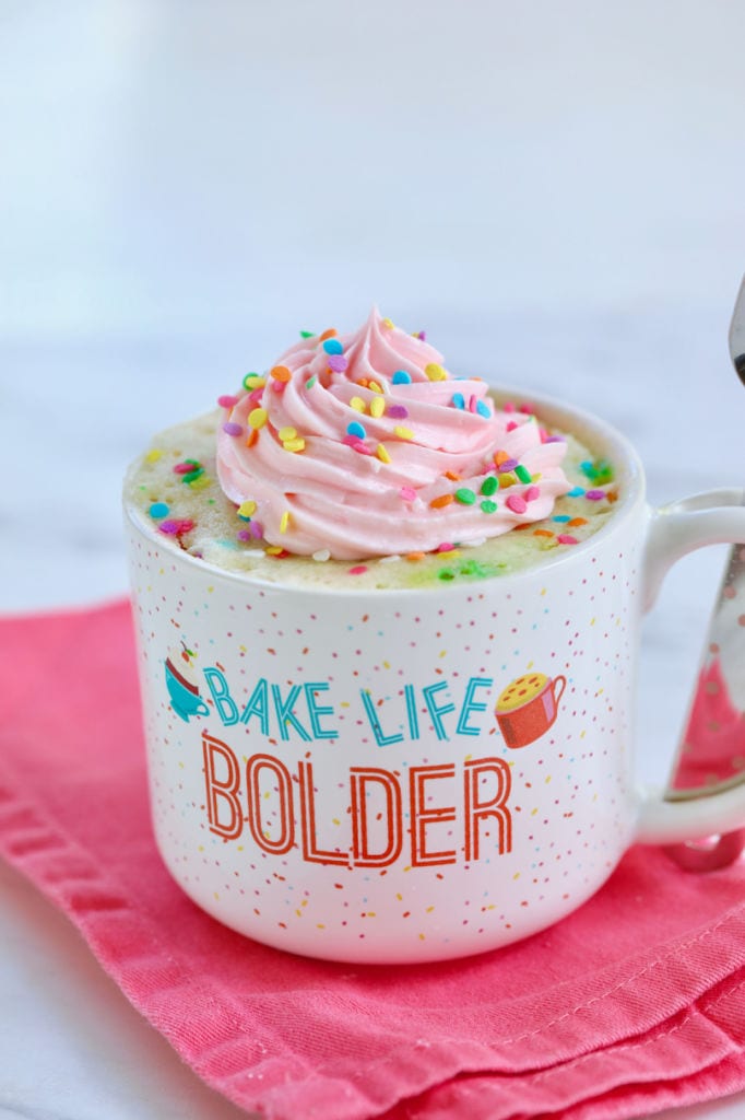 Finished Best-Ever Vanilla Mug Cake, topped with pink frosting and sprinkles.