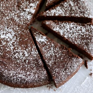 The rich Sugar-Free chocolate cake is dusted with powdered sugar and sliced.