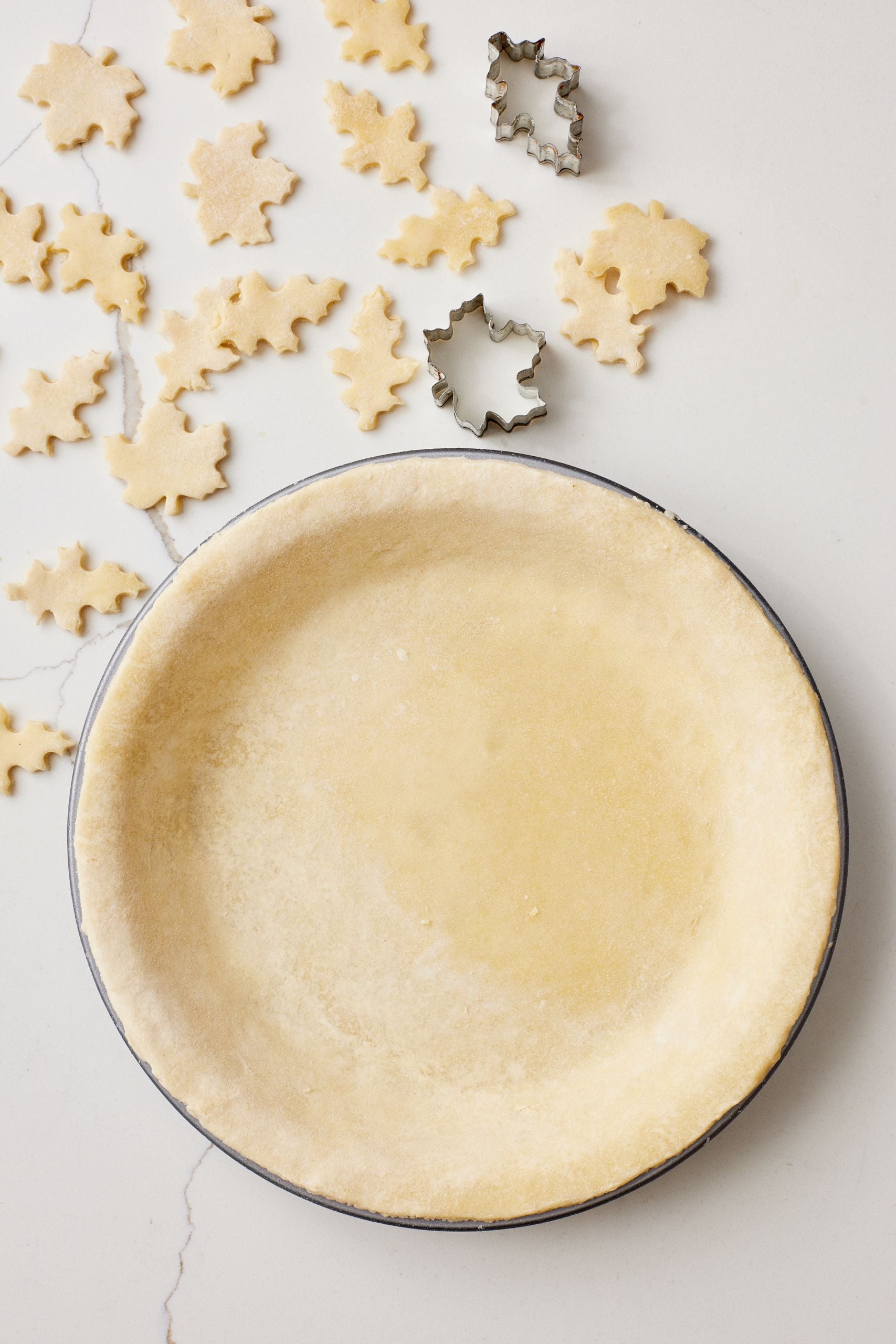 Step-by-step instructions on how to make the Best Pumpkin Pie: roll out the crust, line it with the pie pan, cut excess dough into small shapes for decoration