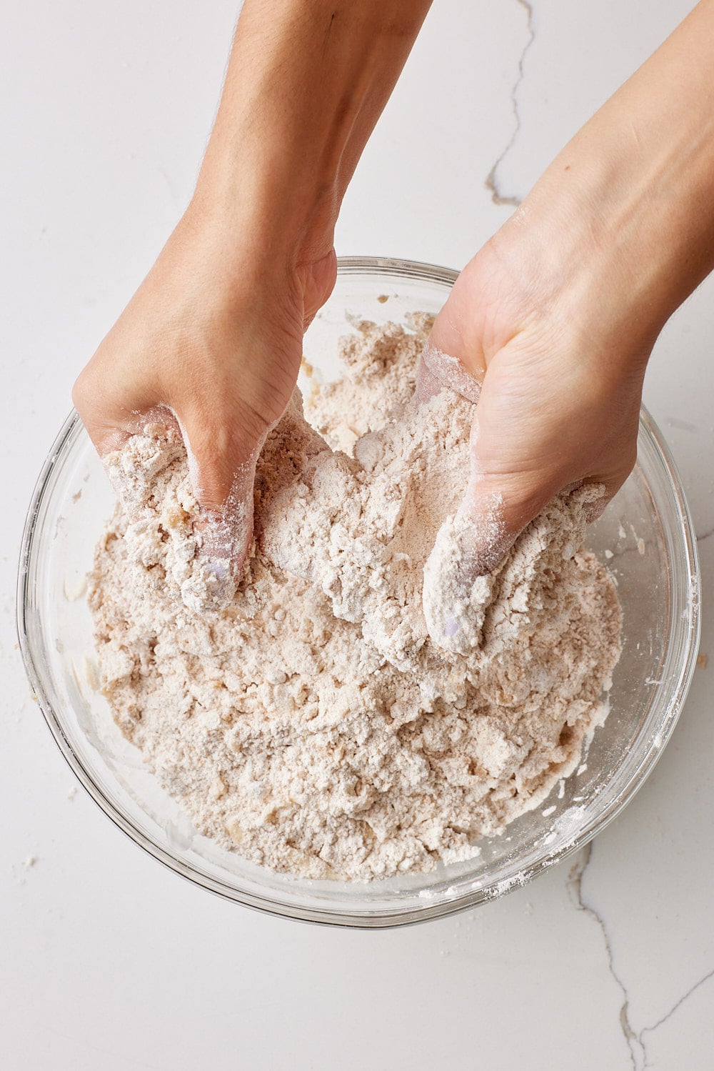Rubbing butter into the mixture by hand.