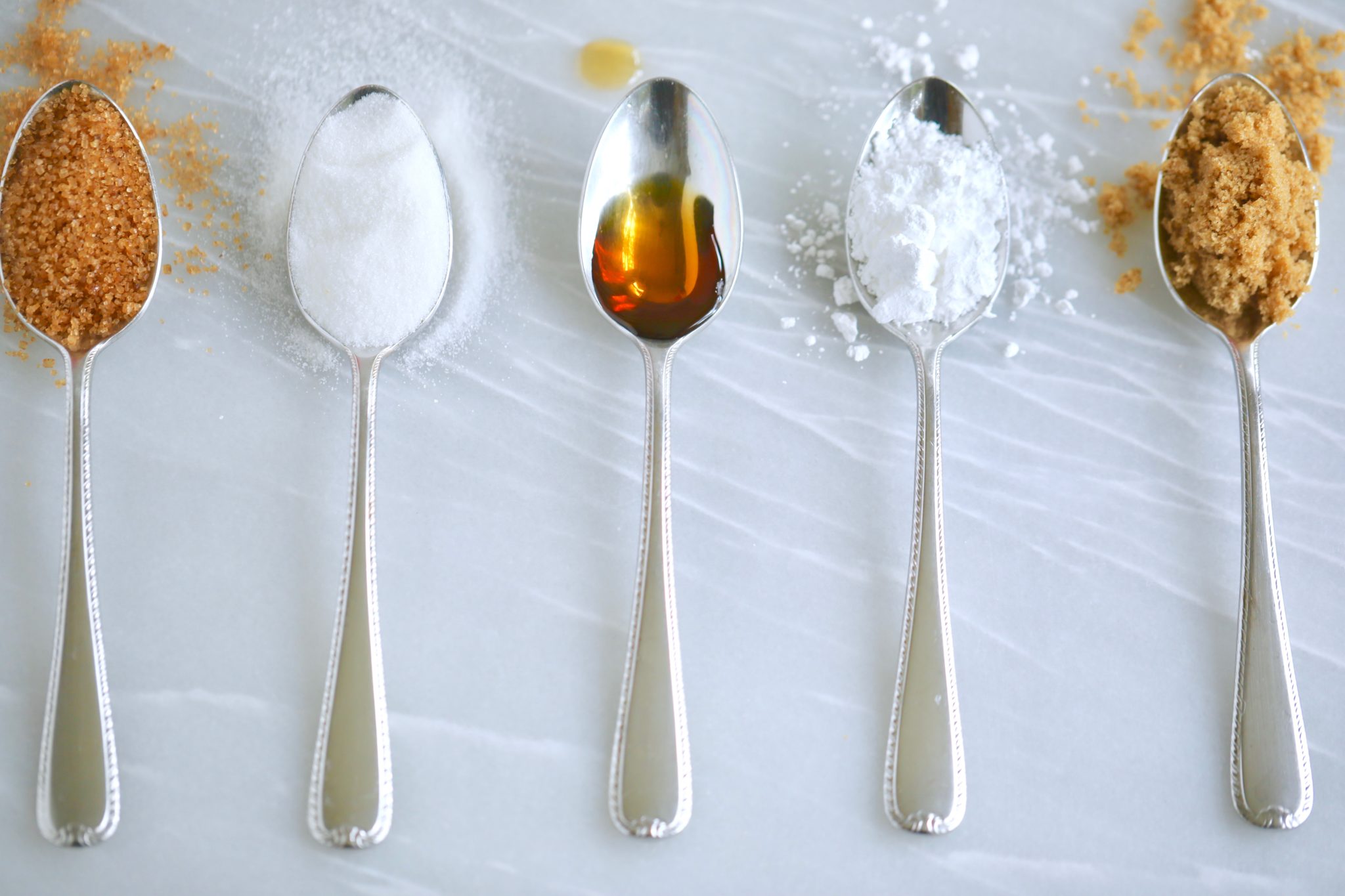 5 spoons with different sugar substitutes.