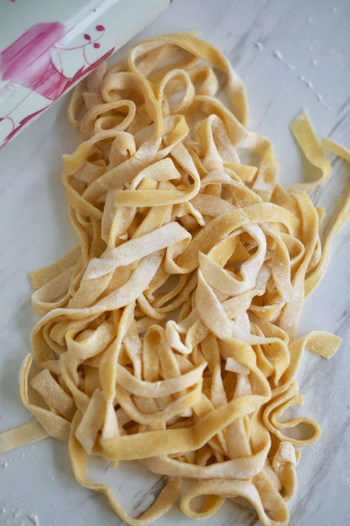 2-Ingredient Homemade pasta is dusted with flour, drying on the working surface.
