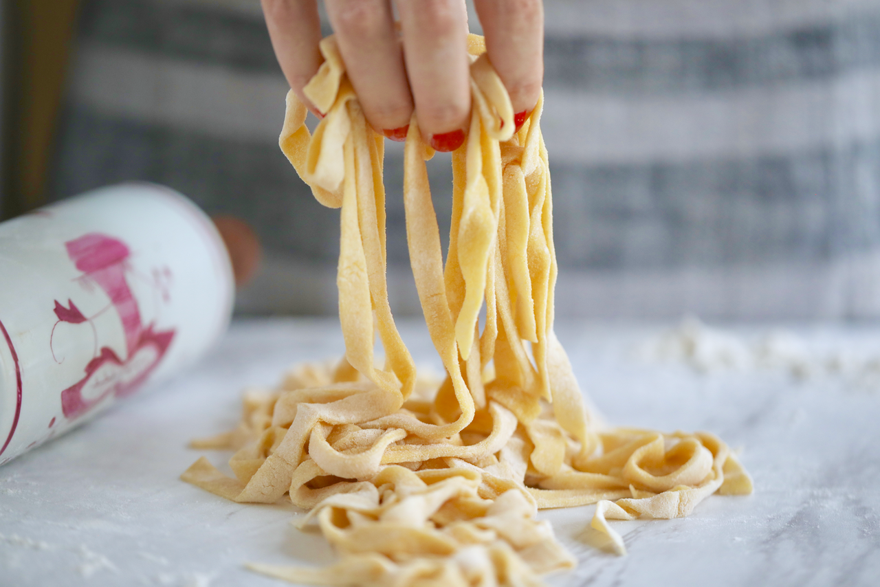 2 Ingredient Homemade Pasta being lifted to show length and texture before cooking.