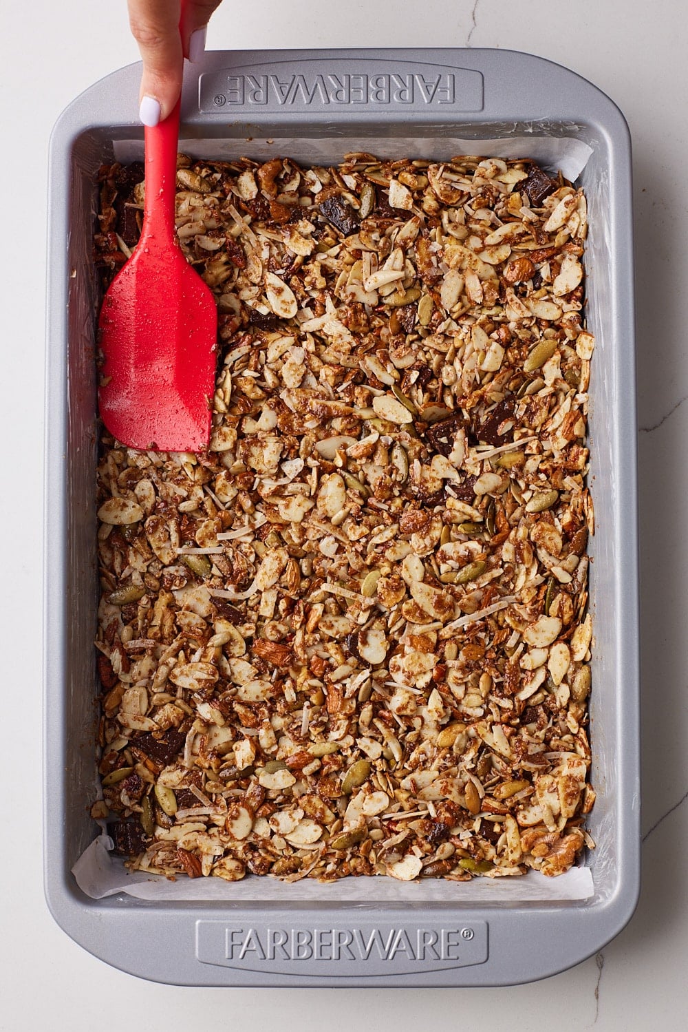 Healthy Granola Bars4 Spread the mixture evenly into the prepared baking tray, using the back of a spatula to press it down firmly. Pressing ensures the bars hold together after baking.