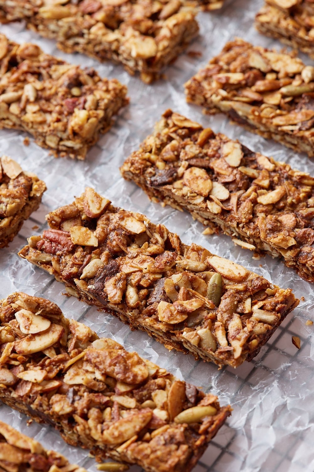 Healthy Granola Bars9 Sliced healthy granola bars on a parchment paper lined cooling rack.