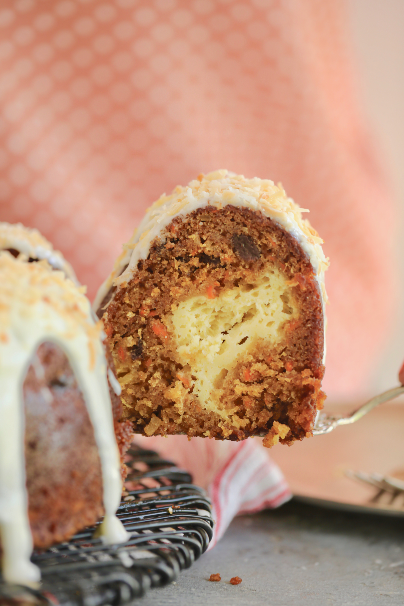 A slice of carrot cake Bundt Cake with a cheesecake filling.