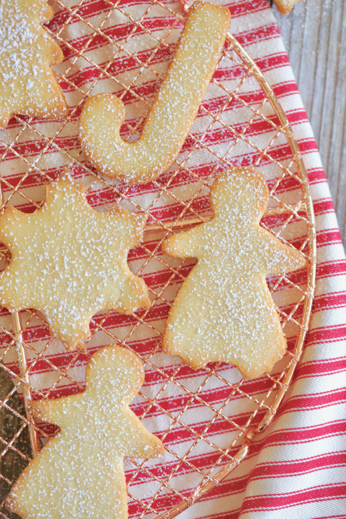 Finished Keto Sugar Cookies, in Christmas shapes, dusted with powdered monkfruit sweetener.