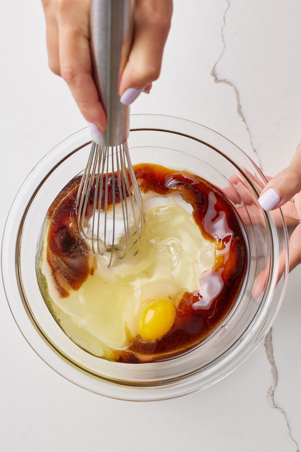 Whisk wet ingredients of molasses cookies together in a bowl. 