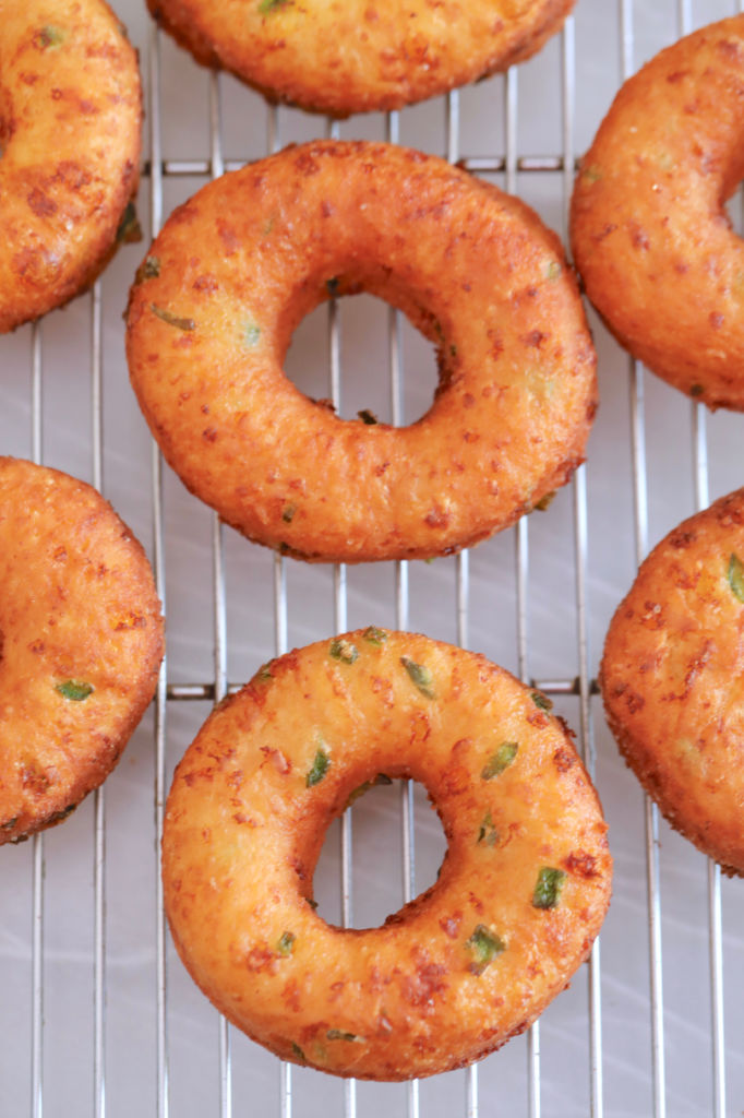 A close up of savory donuts showing the cheddar and jalapeno after being fried.