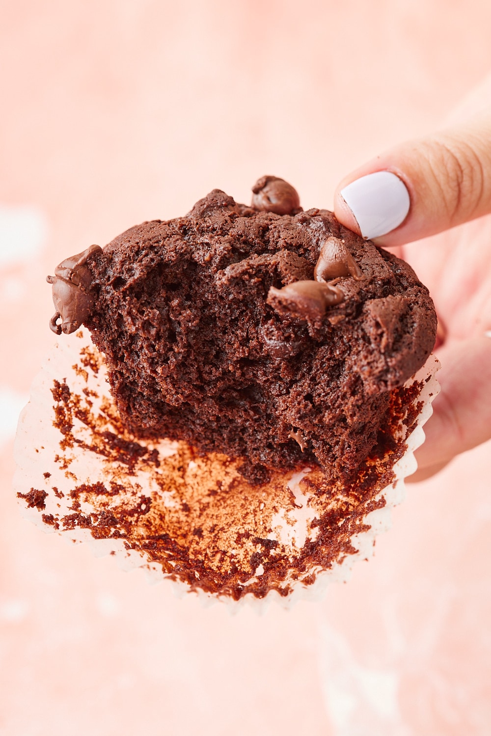 Double Chocolate Chip Muffins11 Close-up of a homemade double chocolate chip muffin broken open to reveal its rich, moist, fudgy crumb with melty chocolate chips throughout.