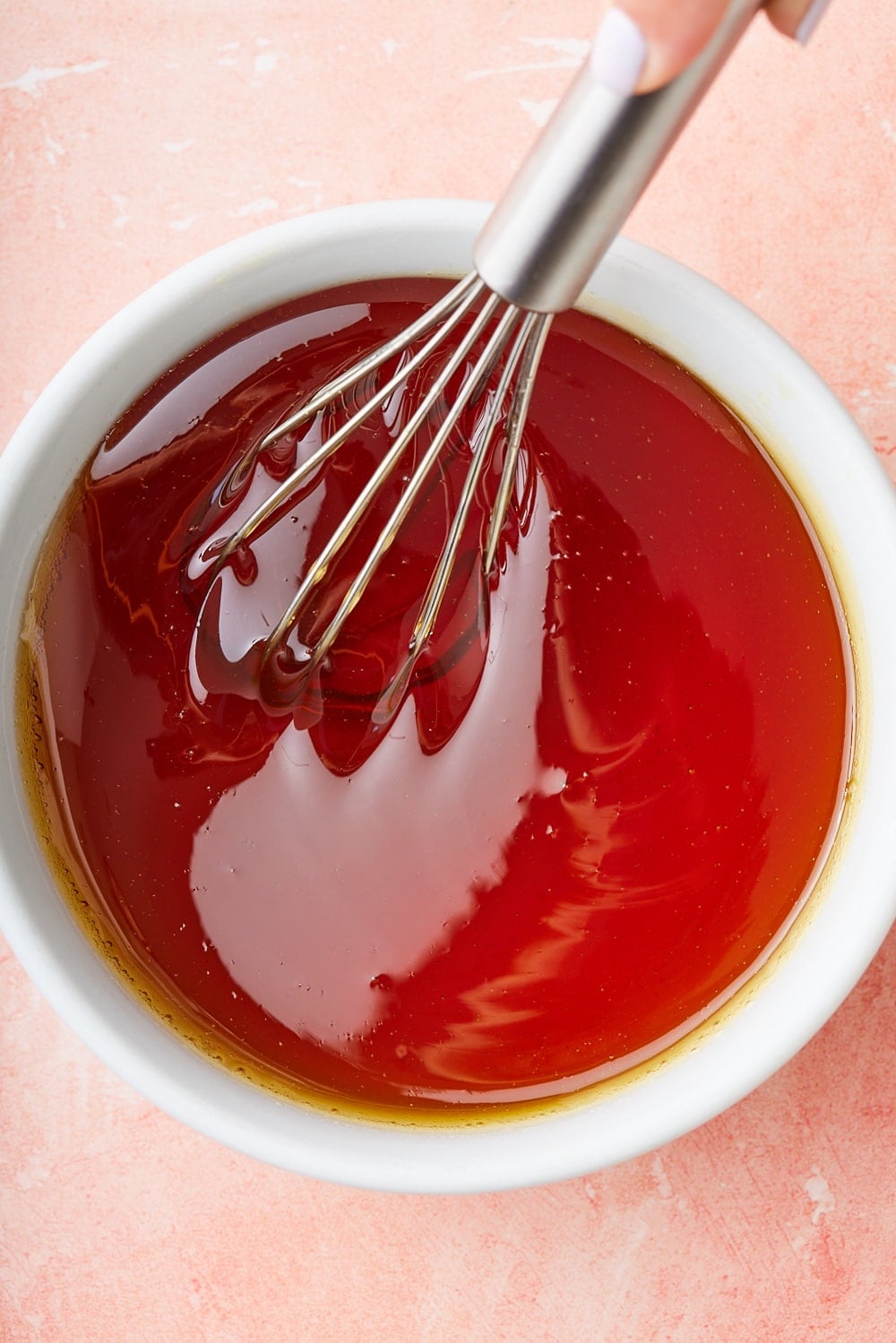 Golden Syrup10 Top-down view of a bowl of golden syrup with a whisk in.