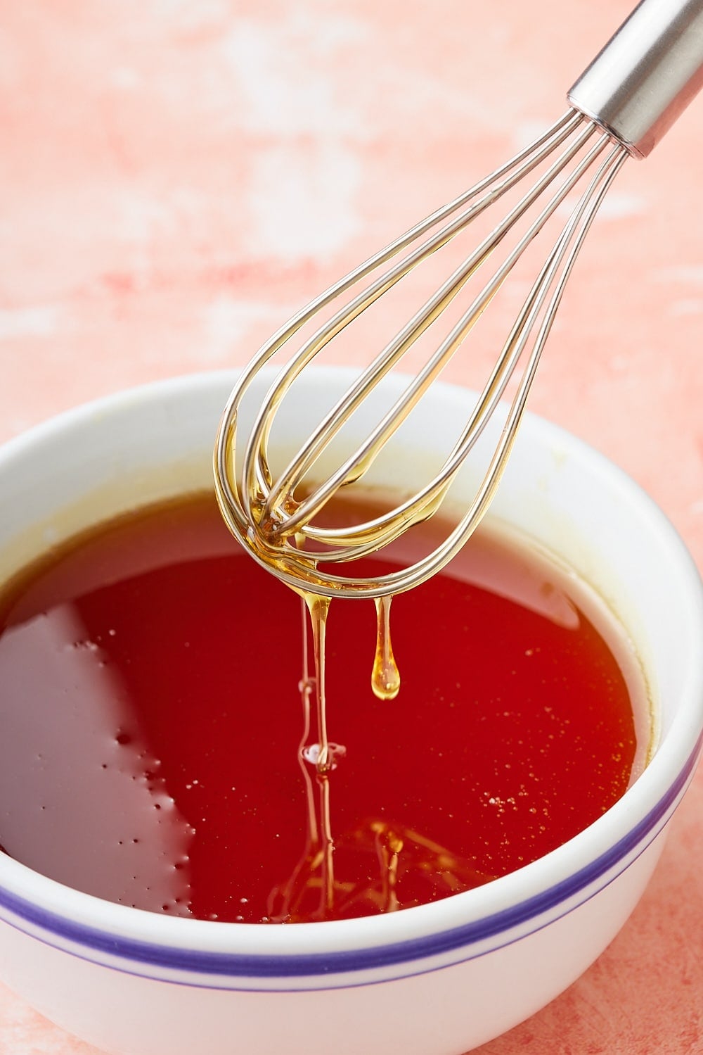 Golden Syrup9 Golden syrup dripping from a whisk into a bowl.