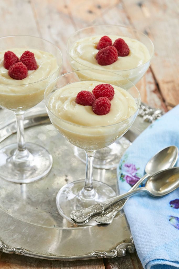 Homemade Vanilla Pudding Recipe, topped with red raspberries, perfect for a simple dessert.