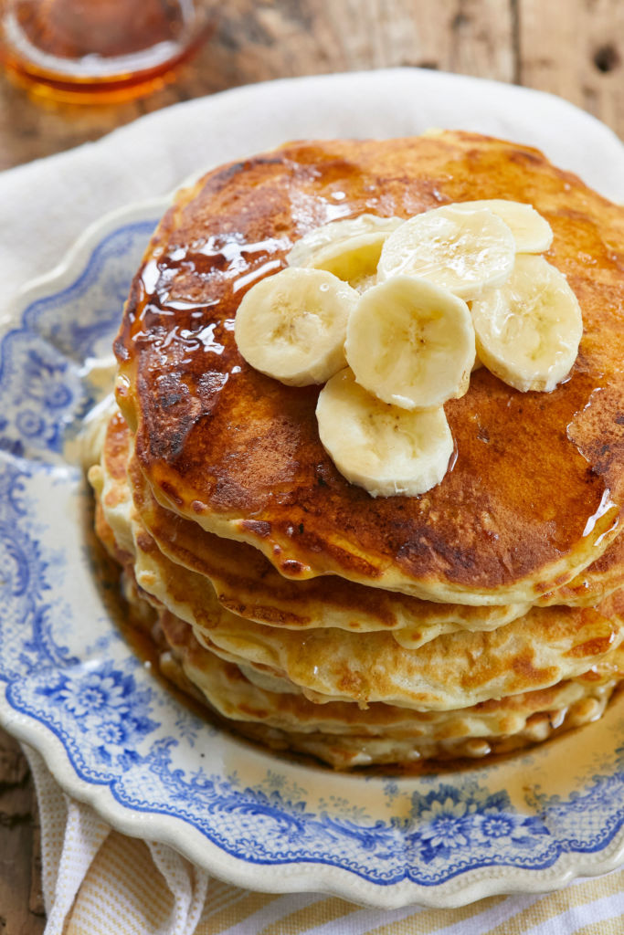 Top view of Banana Pancakes, dripping with syrup and bananas.