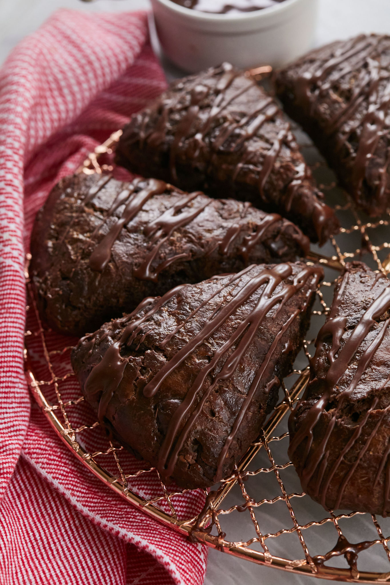 A tray of double chocolate scones, drizzled with chocolate, and cut into triangles.