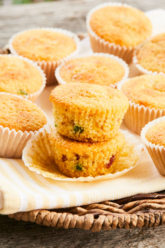 Two cornbread muffins, or corn muffins, stacked on top of each other with jalapeños inside.