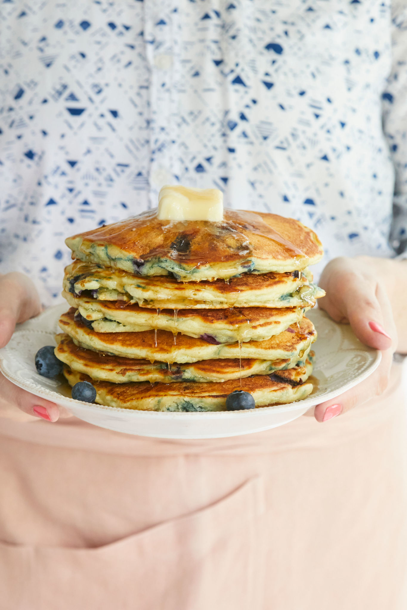 Gemma Stafford holding a stack of her Homemade Blueberry Pancakes recipe.