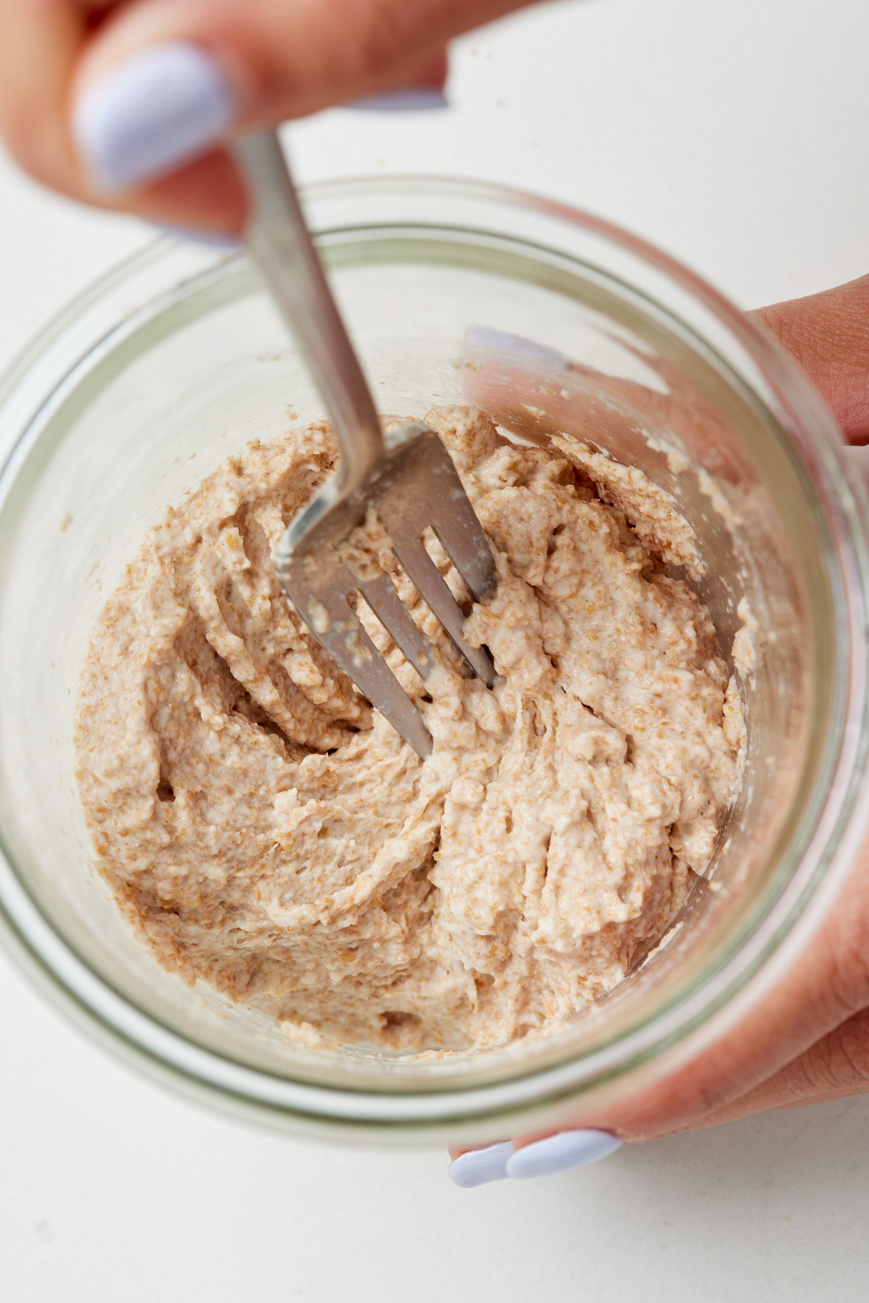 Step-by-step instructions on how to make sourdough starter: mix whole wheat flour and water until smooth.