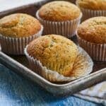 Lemon Poppy Seed muffins in paper liners on a baking sheet.