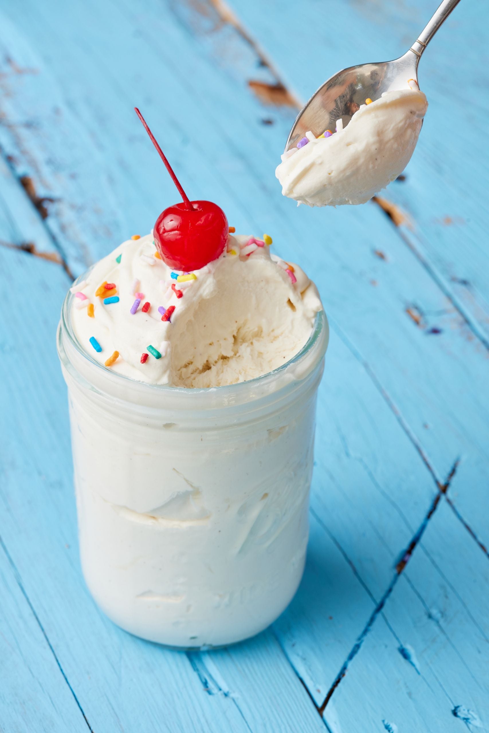 A spoonful of vanilla mason jar ice cream over the jar